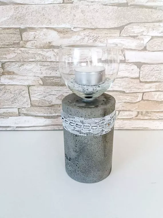 Dekorative Vase aus Beton mit einem Glas oben und einer kleinen Kerze