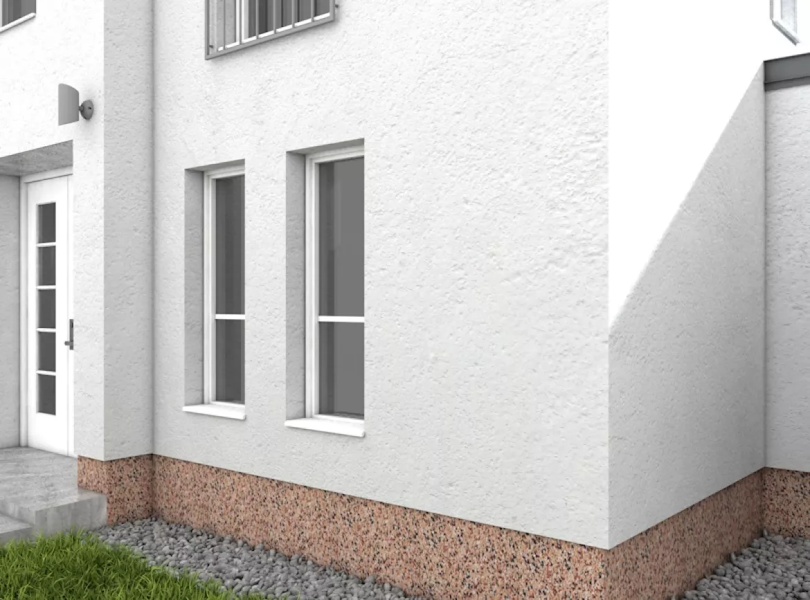 Neu verputzter Fassadensockel eines weißen Hauses