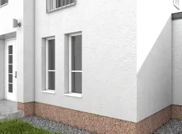 Neu verputzter Fassadensockel eines weißen Hauses